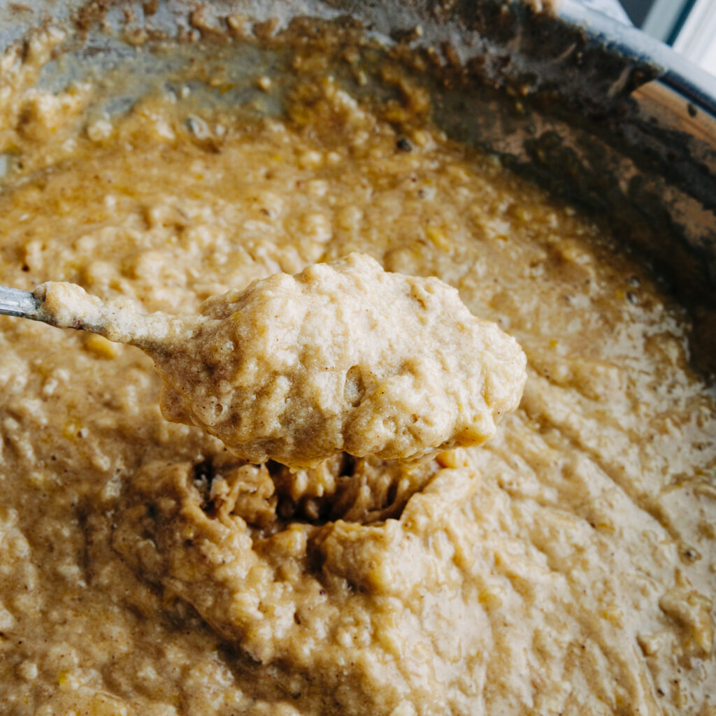 After folding 250g of whole cell crushed wheat into the wet banana mixture, showing a thick and hearty texture.