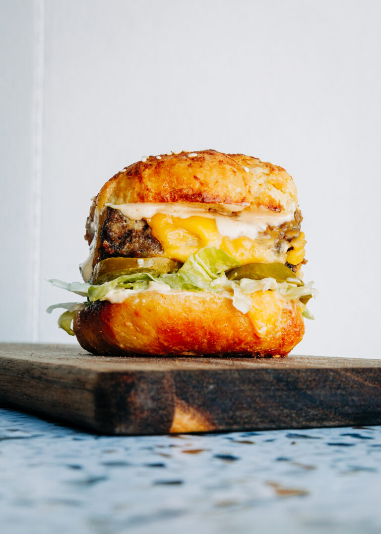 Homemade Big Mac slider made with clean ingredients, layered with gooey cheese, tangy pickles, and fresh shredded lettuce.