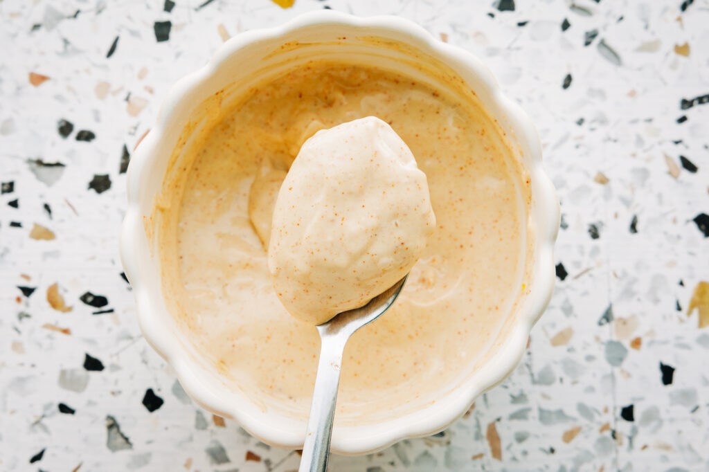 Homemade clean ingredient copycat Applebee's garlic mayo in a small bowl, a creamy sauce for mushroom swiss sliders.