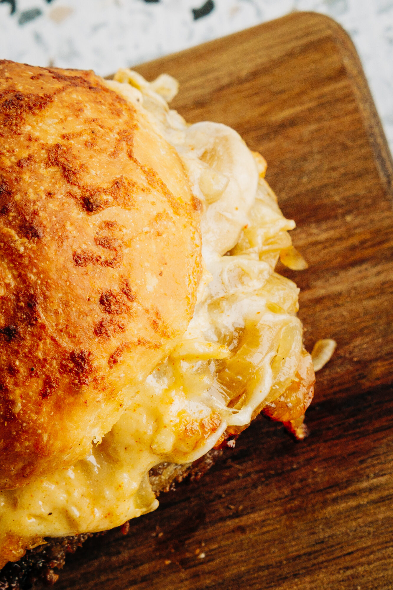 Extreme close-up of a Mushroom Swiss burger slider, showing the sautéed mushrooms and a dollop of garlic mayo.
