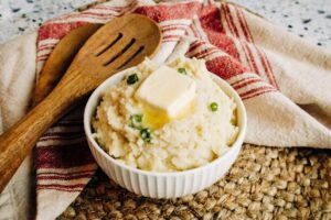 creamy mashed potatoes made in an instant pot and topped with chives and butter